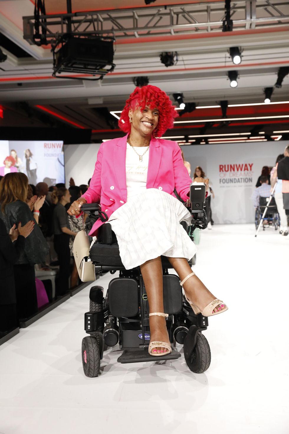 A Disabled LGBTQ+ model showcases adaptive design at a \u200bRunway of Dreams Foundation fashion show.