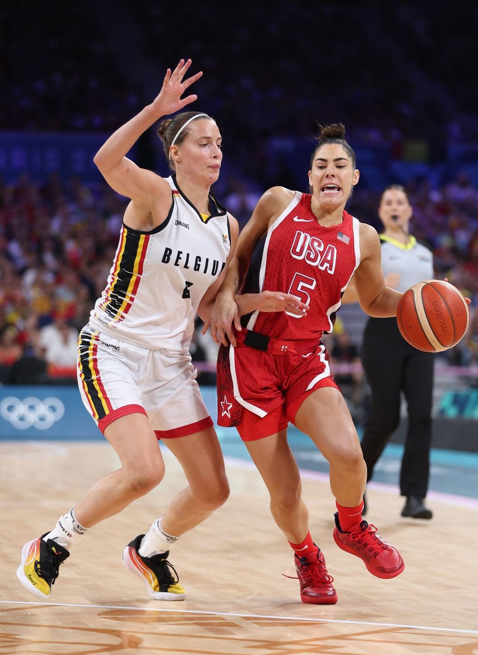 LILLE, FRANCE - AUGUST 01: Kelsey Plum #5 of Team United States reacts while driving past Antonia Delaere #6 of Team Belgium during a Women's Basketball Group Phase - Group C game between the United States and Belgium on day six of the Olympic Games Paris 2024 at Stade Pierre Mauroy on August 01, 2024 in Lille, France. (Photo by Gregory Shamus/Getty Images)