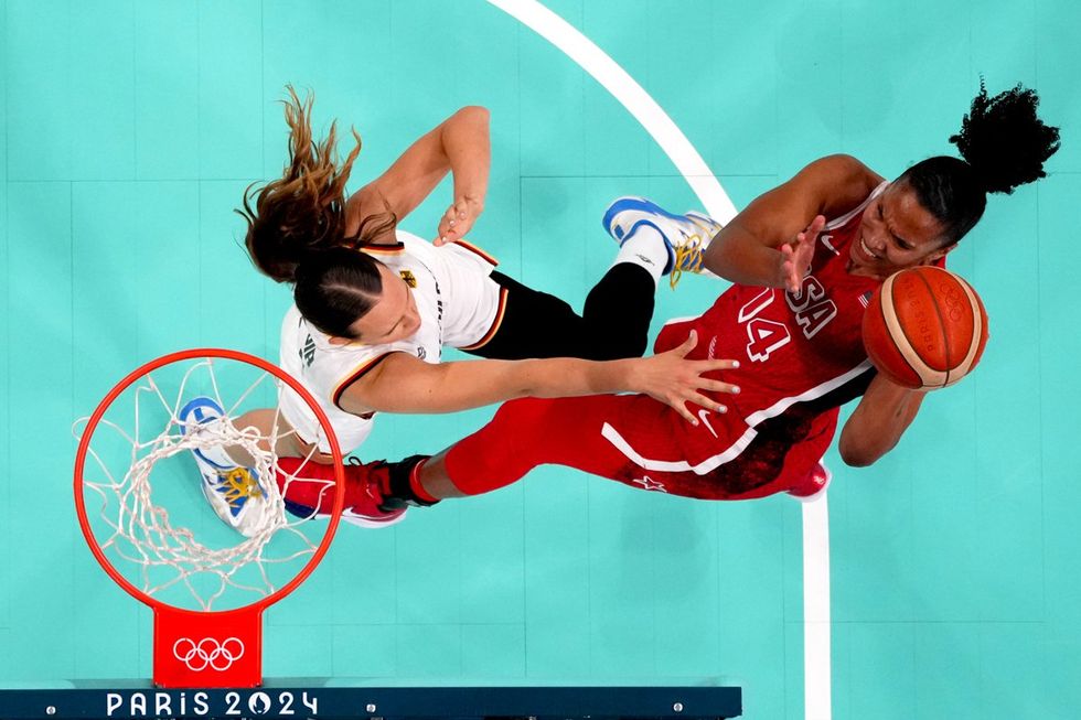 LILLE, FRANCE - AUGUST 04: (EDITORS NOTE: Image was captured using a remote camera positioned above the field of play) Alyssa Thomas #14 of Team United States shoots over Emily Bessoir #22 of Team Germany during a Women's basketball Group Phase - Group C game between the United States and Germany on day nine of the Olympic Games Paris 2024 at Stade Pierre Mauroy on August 04, 2024 in Lille, France. (Photo by Pool/Getty Images)