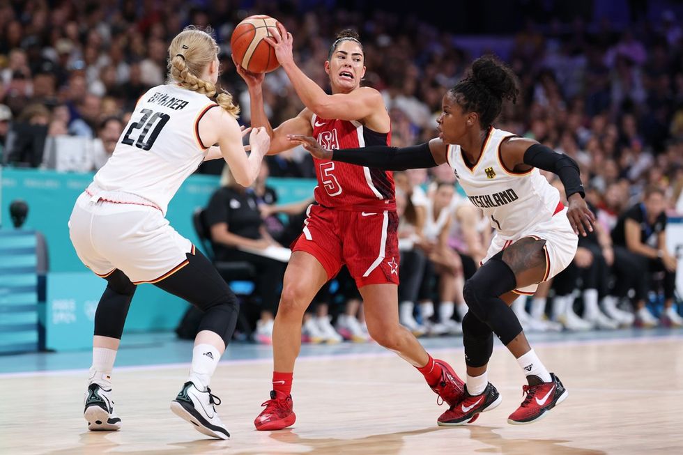 LILLE, FRANCE - AUGUST 04: Frieda Buhner #20 and Alexis Peterson #1 of Team Germany defend Kelsey Plum #5 of Team United States during a Women's basketball Group Phase - Group C game between the United States and Germany on day nine of the Olympic Games Paris 2024 at Stade Pierre Mauroy on August 04, 2024 in Lille, France. (Photo by Gregory Shamus/Getty Images)