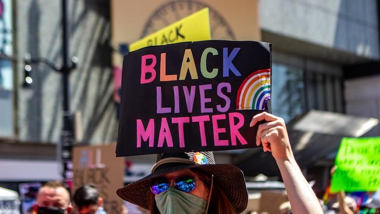 protester holding a sign that says Black Lives Matter